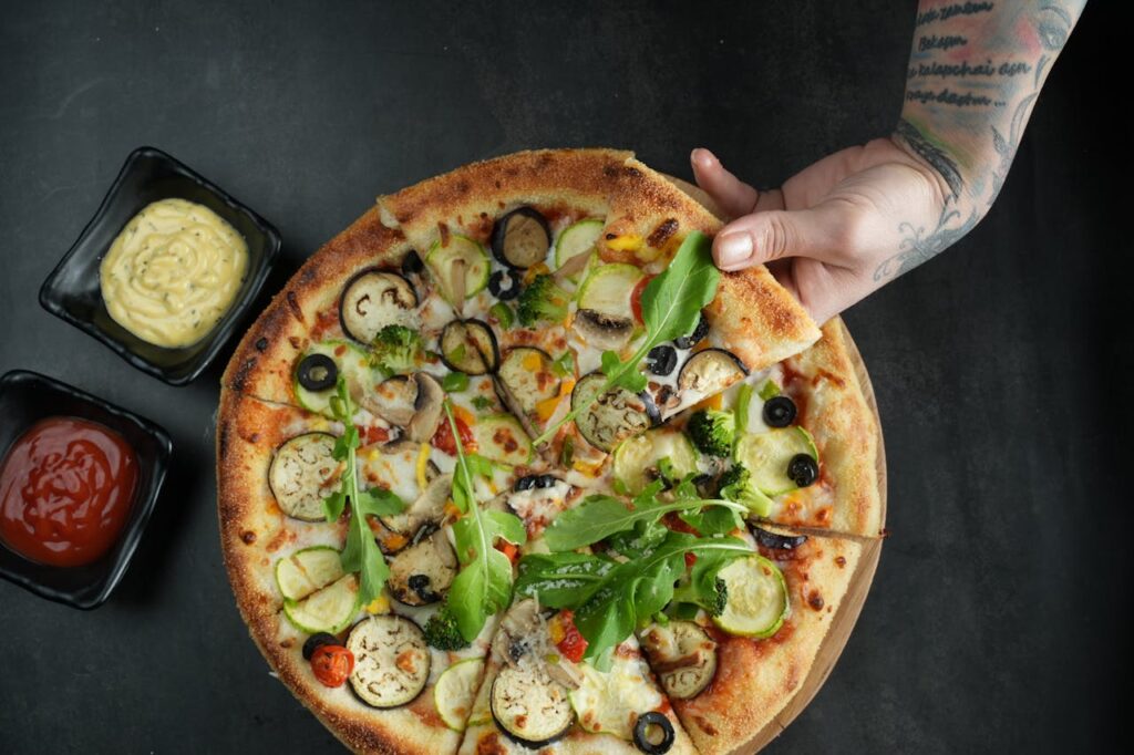 Top view of a vegetarian pizza with fresh toppings and sauces